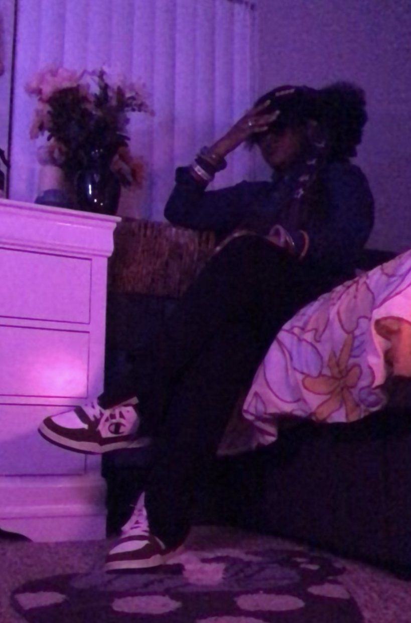 Nelle in purple after-hours light, mid-thought